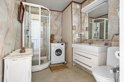 Progetto bagno piccolo rettangolare: bagno compatto con doccia a angolo, lavatrice, mobile lavabo con cassetti e specchio, wc e mobili sfruttati per soluzioni salvaspazio.